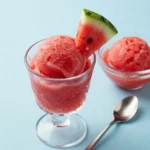 A scoop of vibrant pink watermelon sorbet served in a bowl.