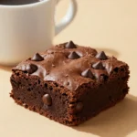 A rich and moist keto chocolate mug cake served in a white mug on a wooden table.