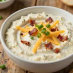 A bowl of creamy Million Dollar Crack Dip surrounded by fresh tortilla chips.