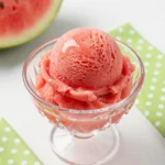 A bowl of homemade watermelon sorbet garnished with fresh mint leaves.