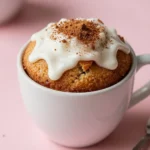 A freshly baked coffee cake in a mug, topped with cinnamon and sugar.