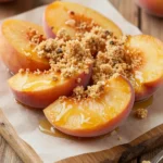 Close-up of peaches and cream crumble bars on a wooden table.