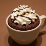 A rich chocolate protein cake served in a white mug, perfect for a quick and healthy dessert.
