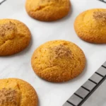 A plate of freshly baked snickerdoodle pumpkin cookies sprinkled with cinnamon sugar.
