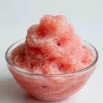 A refreshing watermelon slushie served in a glass with a slice of watermelon.