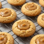 A close-up of freshly baked peanut butter cookies on a cooling rack.