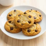 Freshly baked soft batch pumpkin chocolate chip cookies arranged on a white plate.