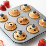 A tray of freshly baked pancake mini muffins with a golden brown top.