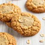 A plate of freshly baked healthy peanut butter oatmeal cookies on a wooden table.