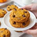 A plate of freshly baked gluten-free pumpkin oatmeal cookies surrounded by fall decorations.