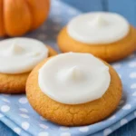 A plate of freshly baked soft pumpkin cookies with a light glaze on top.