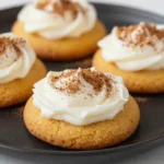 A plate of freshly baked low-calorie pumpkin cookies served on a wooden table.