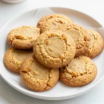 A batch of freshly baked peanut butter cookies on a cooling rack.