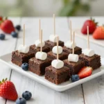Fourth of July brownie kabobs with brownies, strawberries, blueberries, and marshmallows on wooden skewers
