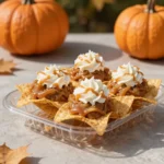 Apple pie nachos with crisp cinnamon sugar tortilla chips topped with warm spiced apples, caramel drizzle, and whipped cream