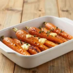 A close-up of honey garlic roasted carrots glazed and caramelized on a baking sheet, garnished with fresh parsley.