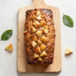 Slice of Easy Amish Apple Fritter Bread topped with a light glaze and visible pieces of cinnamon apple