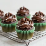 Easy football cupcakes decorated with green frosting, chocolate football toppers, and sprinkles for a game day dessert.