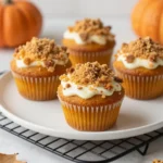 Freshly baked cream cheese pumpkin spice muffins with a soft golden top, displayed on a plate