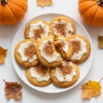 Plate of soft pumpkin cookies made with cake mix, dusted with cinnamon sugar and arranged on a rustic kitchen table