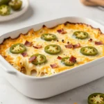 Creamy jalapeño popper dip topped with melted cheese, chopped jalapeños, and crispy breadcrumbs served in a baking dish with tortilla chips.