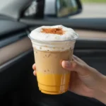 A Starbucks Pumpkin Cream Cold Brew served in a clear glass with whipped pumpkin cream, ice, and a dark coffee base.