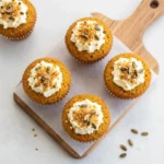 Freshly baked pumpkin muffins topped with a light dusting of sugar on a cooling rack