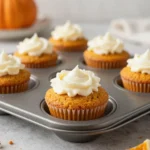 Fresh flourless pumpkin muffins topped with a light dusting of cinnamon on a rustic plate