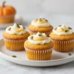 Homemade copycat Starbucks pumpkin cream cheese muffins on a plate with a light dusting of cinnamon.