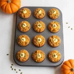 Homemade Starbucks-style pumpkin muffins topped with crumbly streusel on a white plate