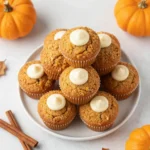 Pumpkin muffins split open to reveal a smooth maple cream cheese filling.
